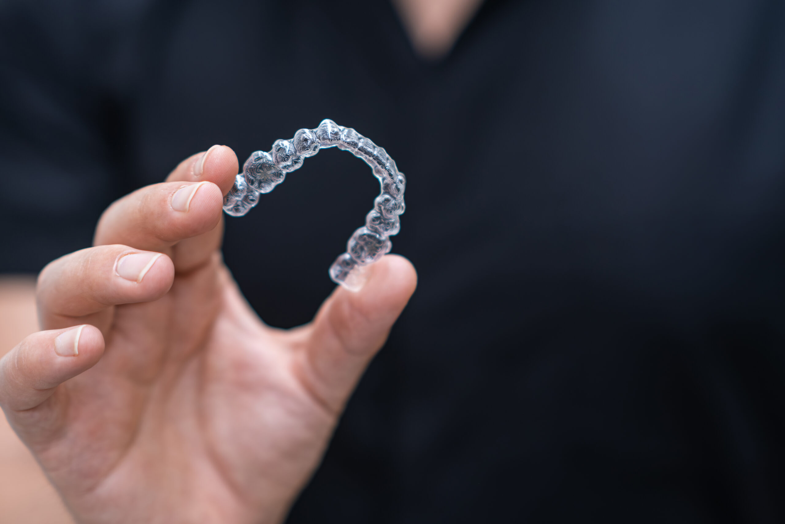 Professional dentist presenting clear aligners orthodontic treatment tool for problematic teeth